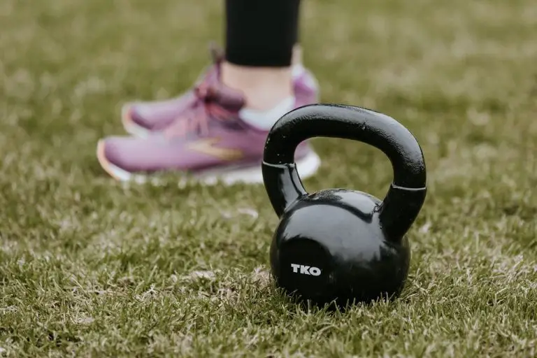 An image of a runner standing beside a kettlebell