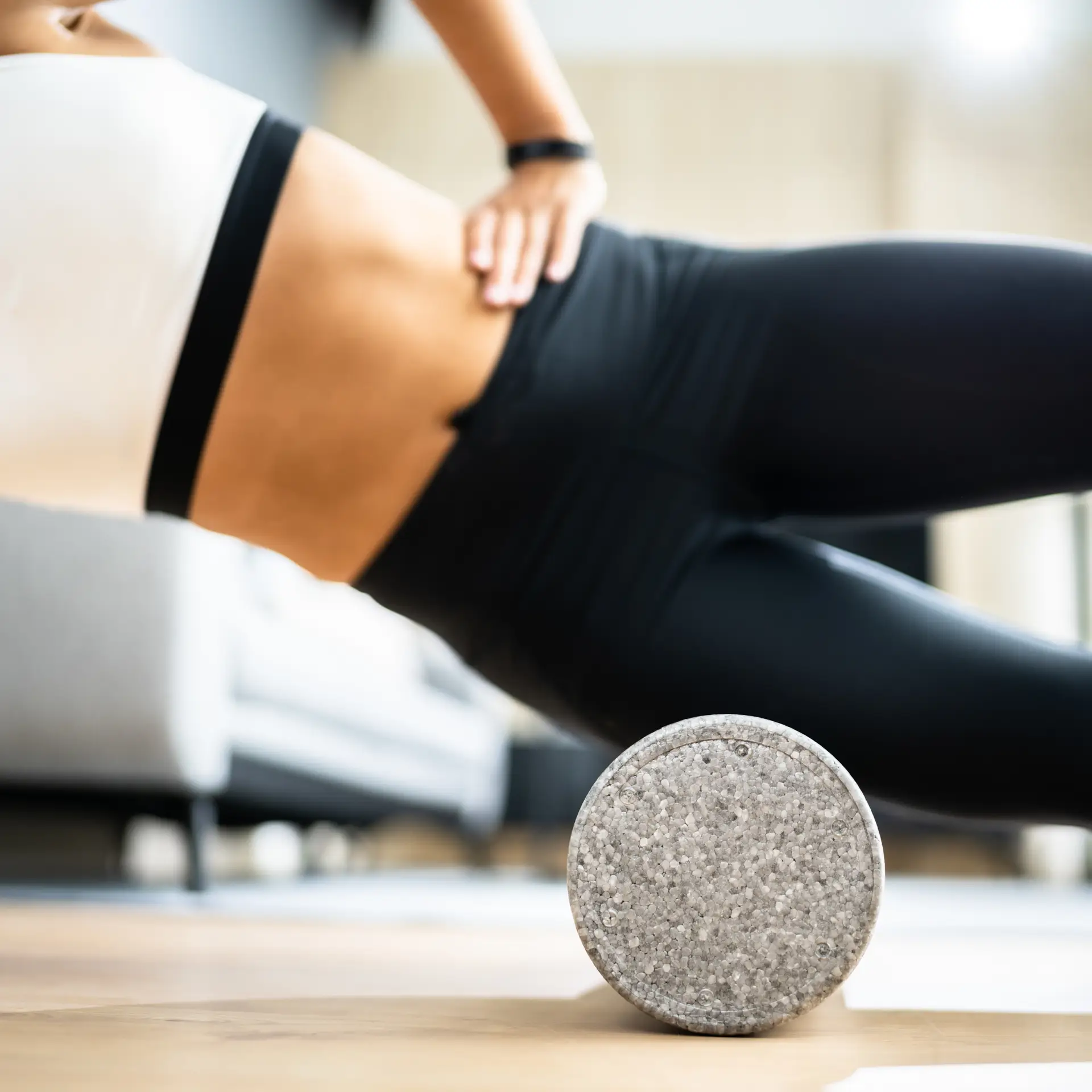 A woman using a foam roller on her IT band