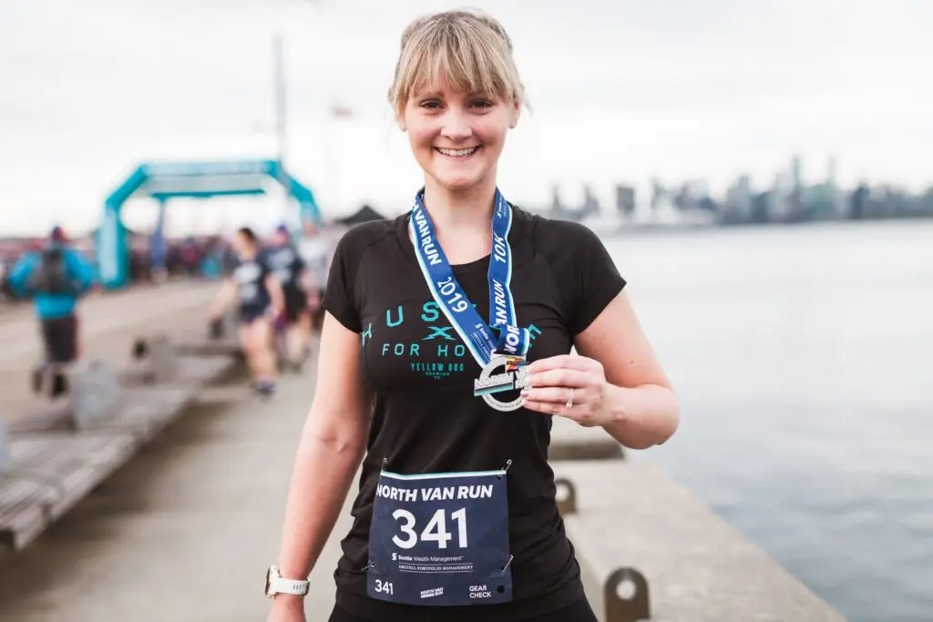 a runner at the end of a race holding a medal